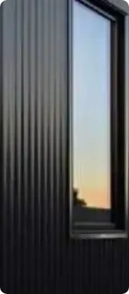 Black metal siding beside a tall window